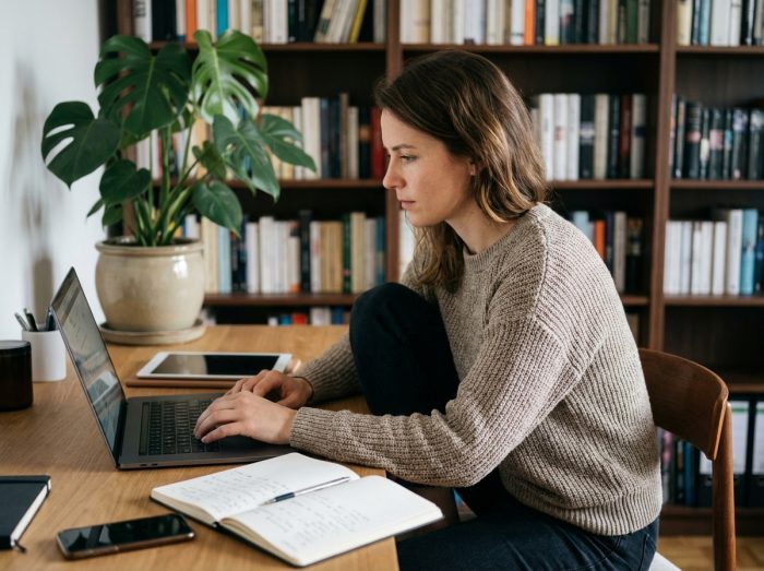 Jeune femme concentrée travaillant à son bureau moderne